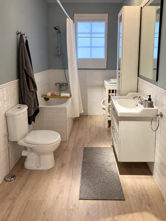 Baño: alicatado blanco y suelo de madera