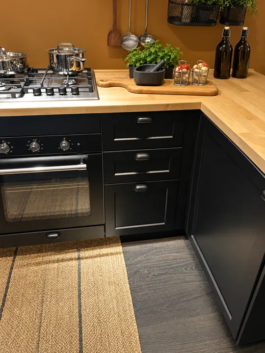 Cocina: mobiliario negro y encimera de madera